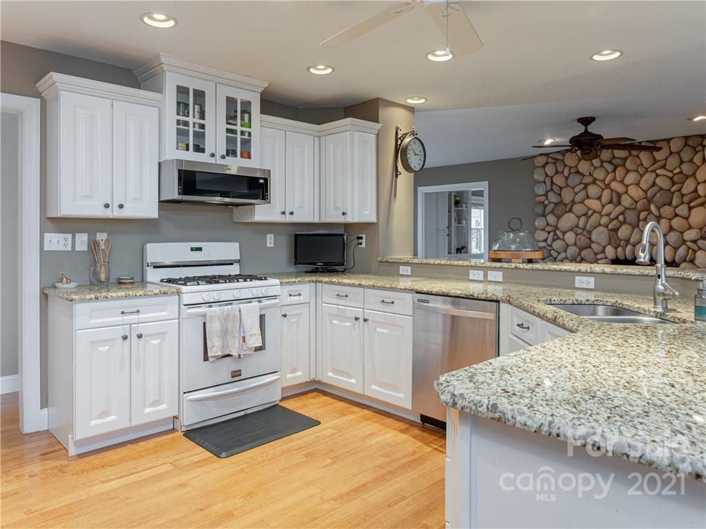 333 Gouges Branch Road Leicester, NC 28748 - Photo 18 of 48 a kitchen with stainless steel appliances granite countertop a sink a stove and a refrigerator