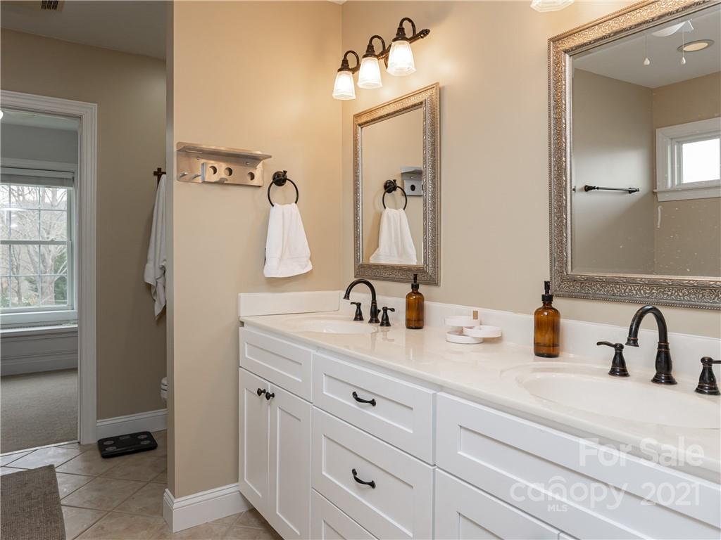 333 Gouges Branch Road Leicester, NC 28748 - Photo 27 of 48 a bathroom with double vanity sinks and a mirror