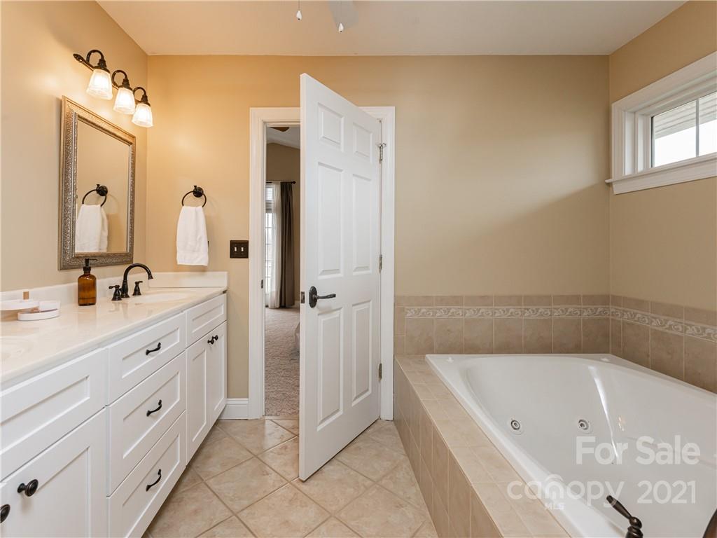 333 Gouges Branch Road Leicester, NC 28748 - Photo 28 of 48 a bathroom with a tub sink and mirror
