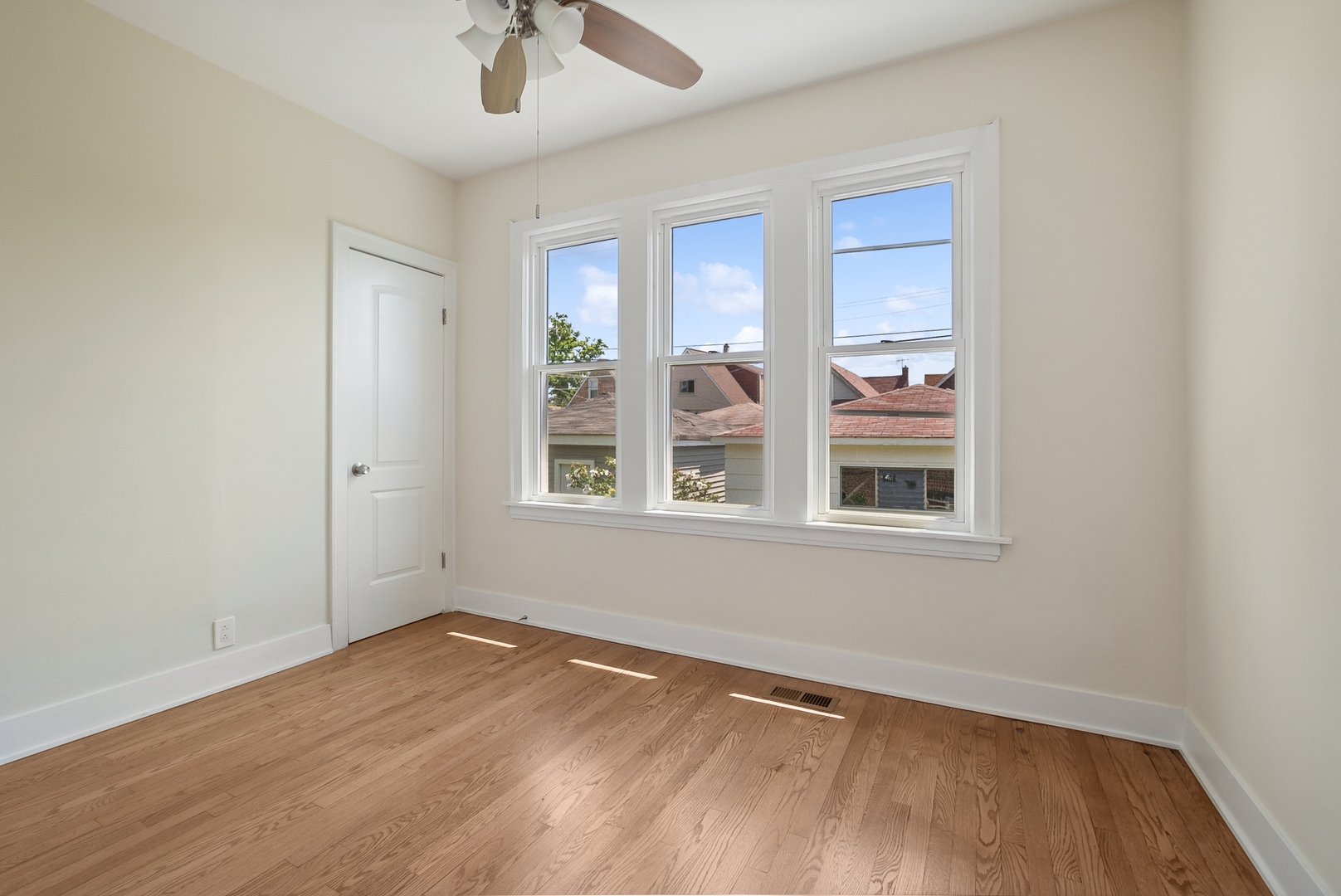 8325 South Perry Avenue Chicago, IL 60620 - Photo 8 of 15 a view of an empty room with a window and wooden floor