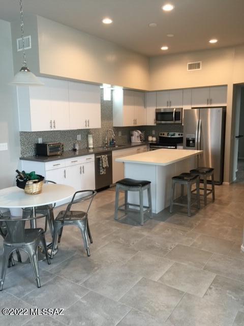 866 East Millenium Court Tucson, AZ 85719 - Photo 4 of 15 a kitchen with stainless steel appliances kitchen island granite countertop a table chairs sink and cabinets