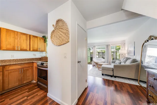 a living room with stainless steel appliances granite countertop furniture a fireplace and wooden floor