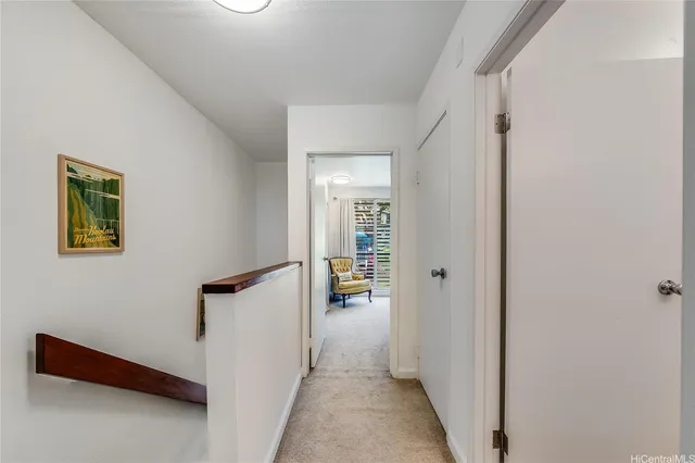 a view of a hallway with wooden floor and a living room