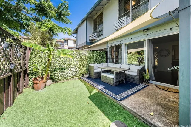 a view of a patio with couches table and chairs and potted plants