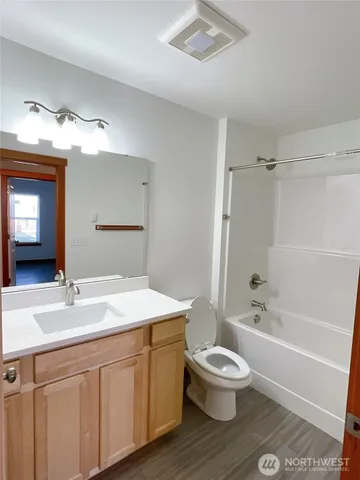 a bathroom with a sink a toilet a mirror and shower