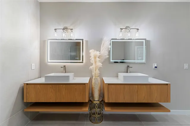 a en suite bathroom with a double vanity sink and mirror