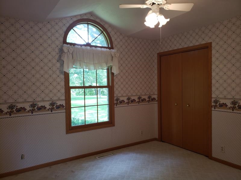 17347 Stimes Road Capron, IL 61012 - Photo 7 of 25 an empty room with windows closet and chandelier fan