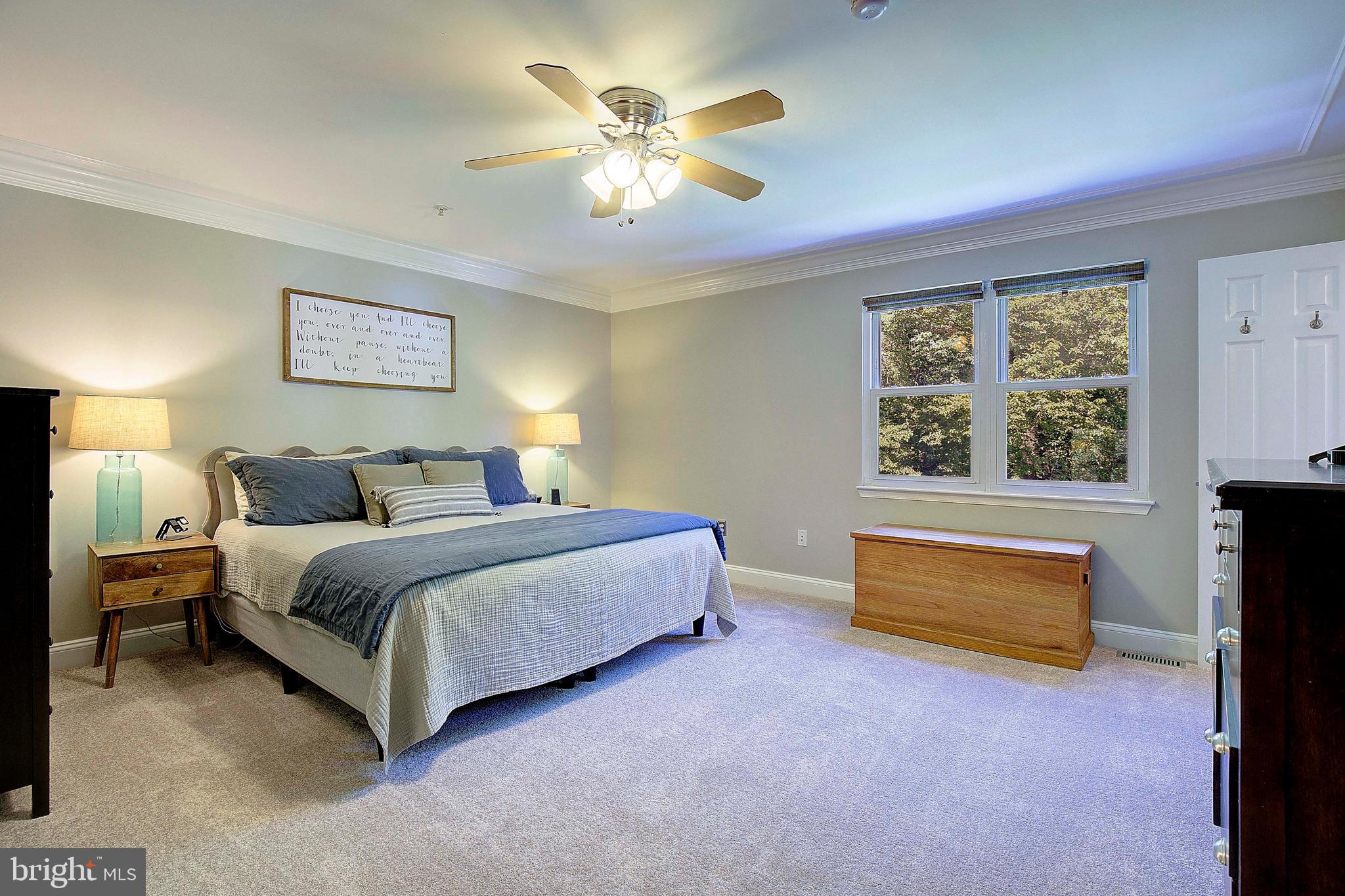 7006 Prout Road Friendship, MD 20758 - Photo 17 of 48 a spacious bedroom with a bed and a chandelier