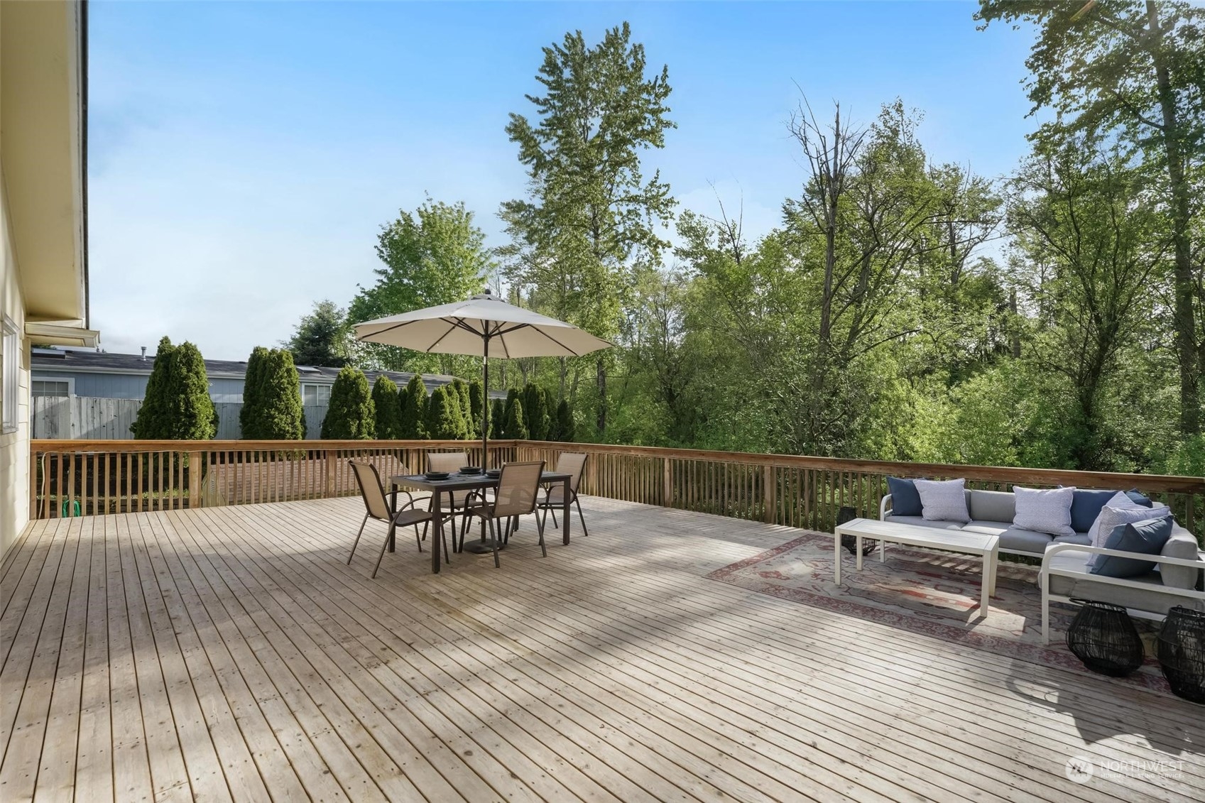 2232 South 330th Street Federal Way, WA 98003 - Photo 15 of 39 a view of a roof deck with table and chairs couches under an umbrella with wooden floor and fence