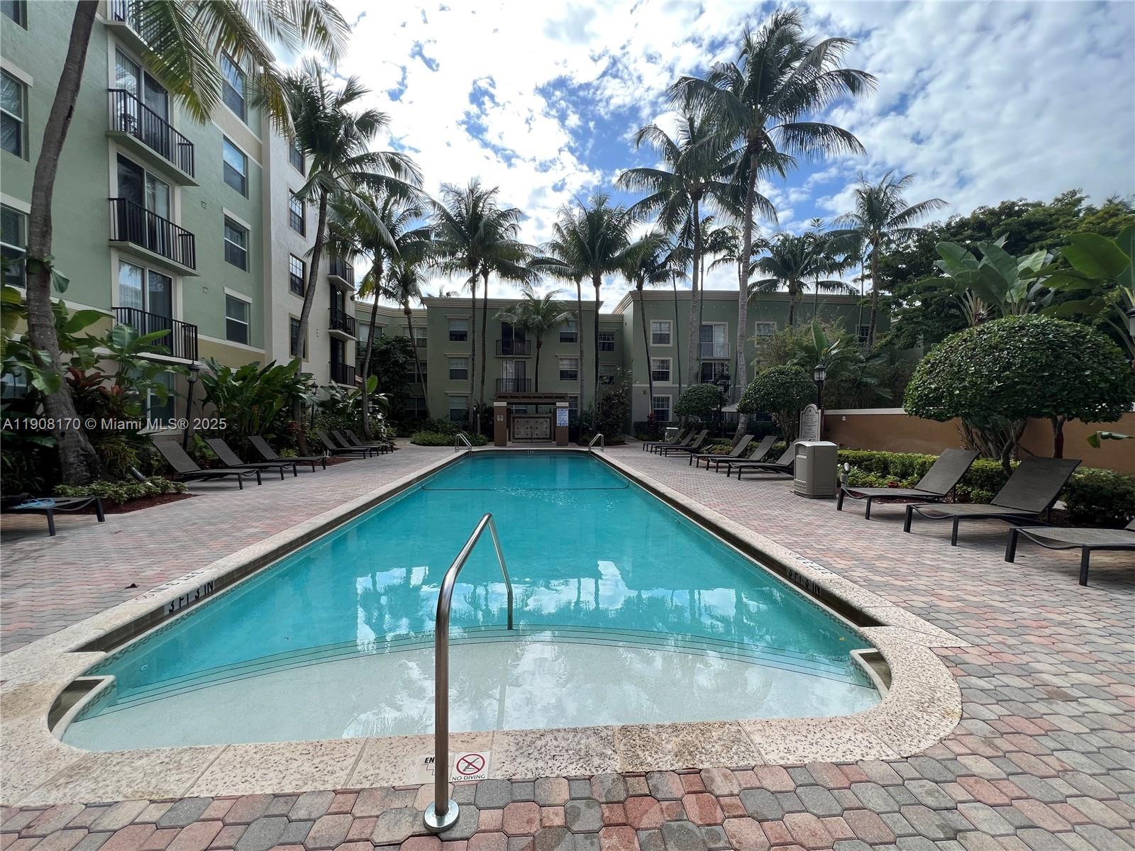 1919 Van Buren Street, Unit 720A Hollywood, FL 33020 - Photo 17 of 22 a swimming pool with outdoor seating and trees
