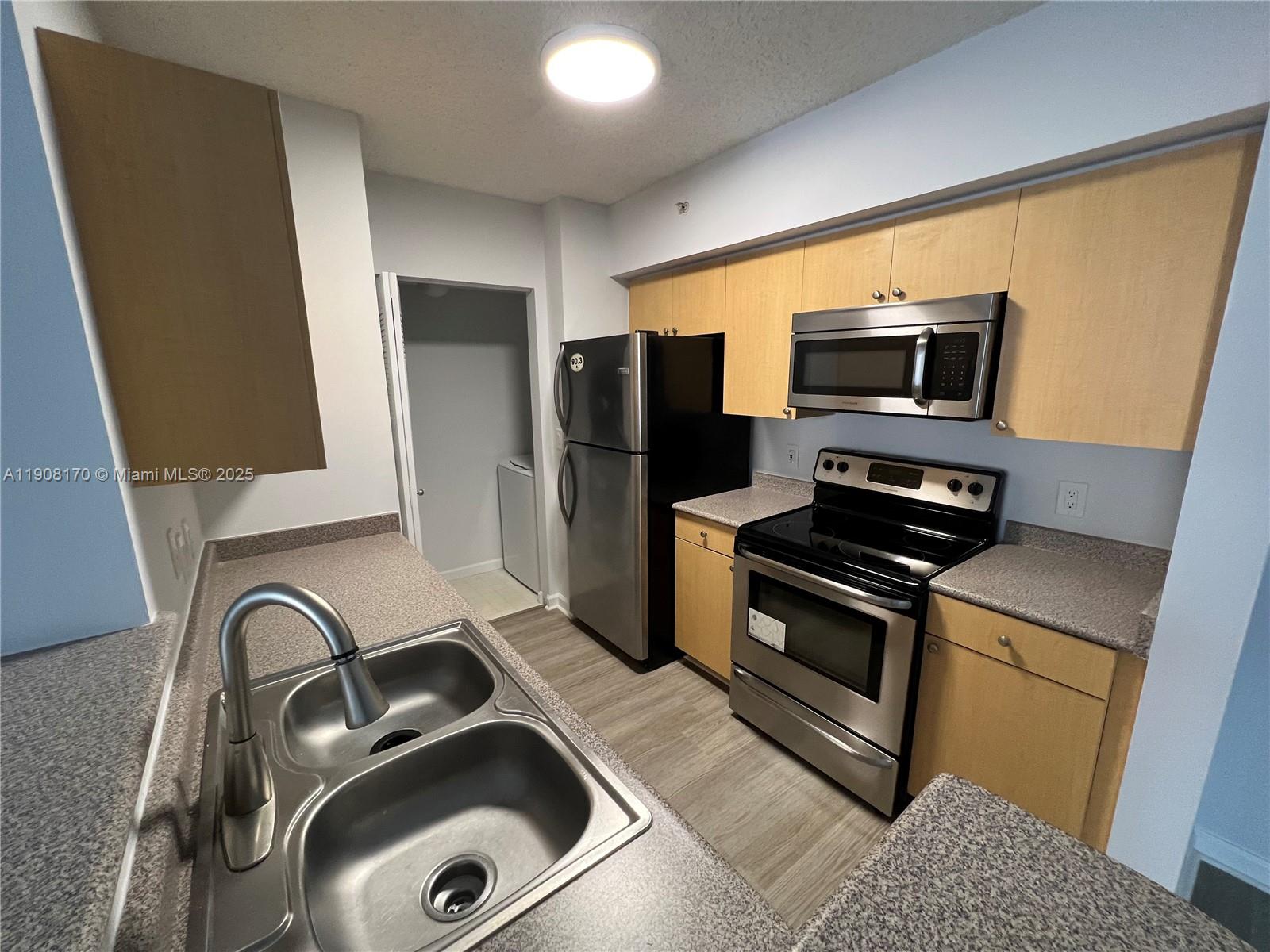 1919 Van Buren Street, Unit 720A Hollywood, FL 33020 - Photo 18 of 22 a kitchen with a sink and stainless steel appliances