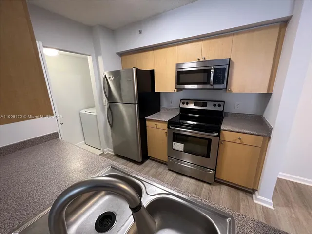 a kitchen with stainless steel appliances a stove a microwave and a refrigerator