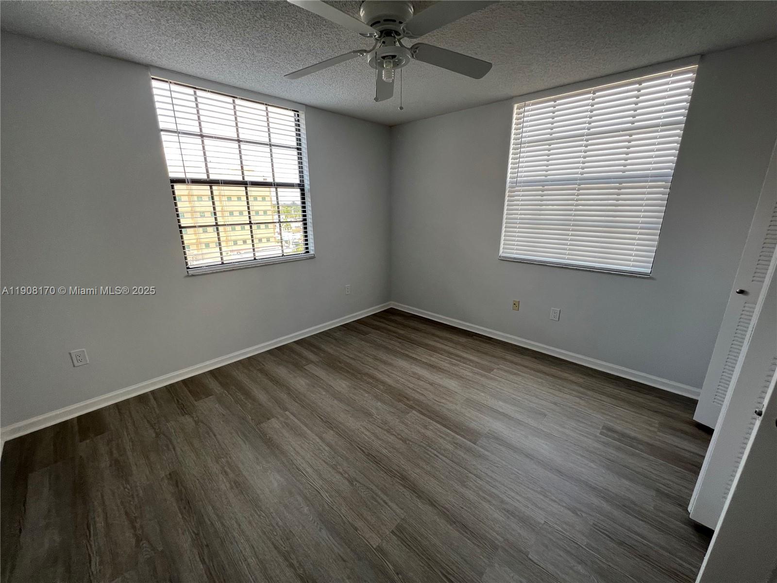 1919 Van Buren Street, Unit 720A Hollywood, FL 33020 - Photo 9 of 22 an empty room with wooden floor chandelier and windows