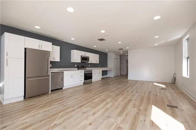 a kitchen with a refrigerator and a stove top oven