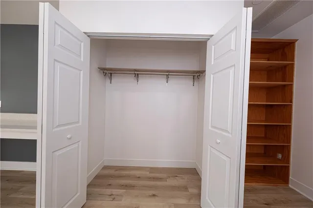 a view of walk in closet with empty racks