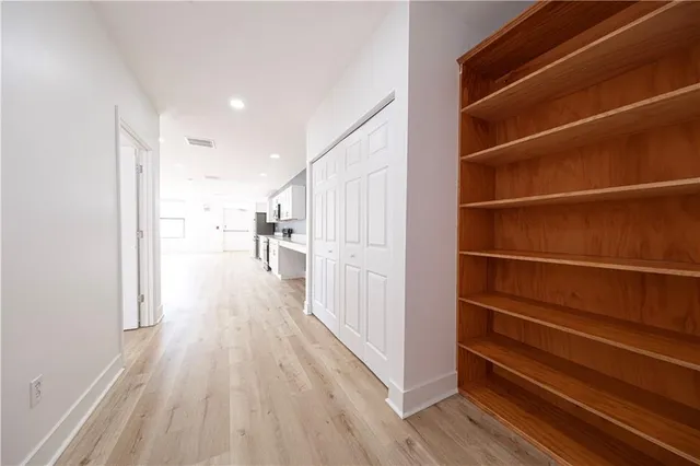 a view of a hallway with wooden floor and staircase