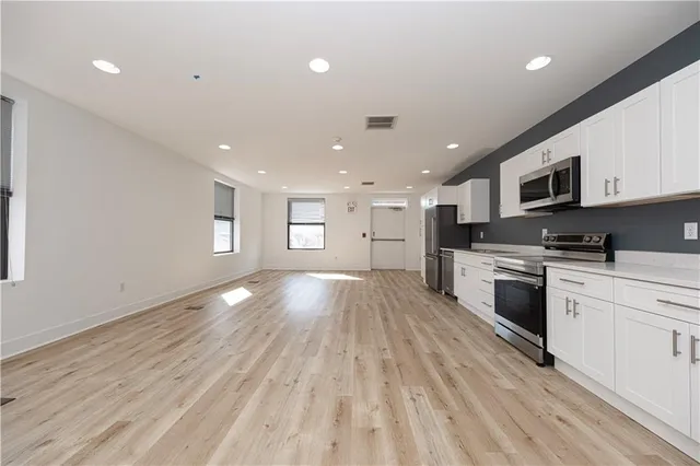 a view of kitchen with sink and refrigerator