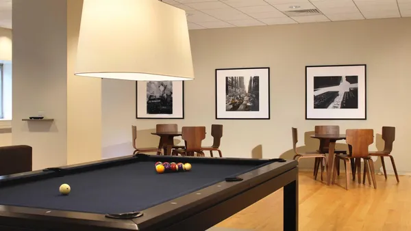 a living room with furniture pool table and window