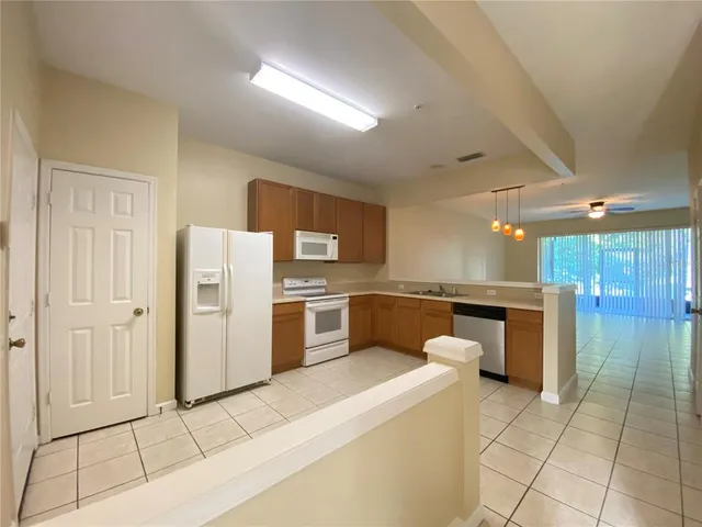 a large white kitchen with a sink cabinets and stainless steel appliances