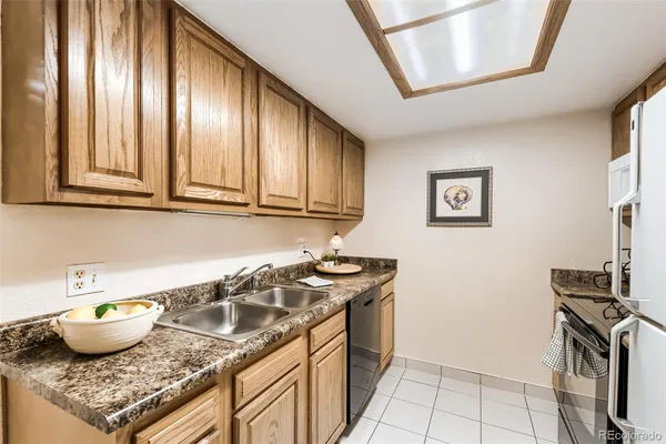 a kitchen with granite countertop a stove top oven and cabinets