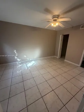 a view of an empty room with a chandelier fan