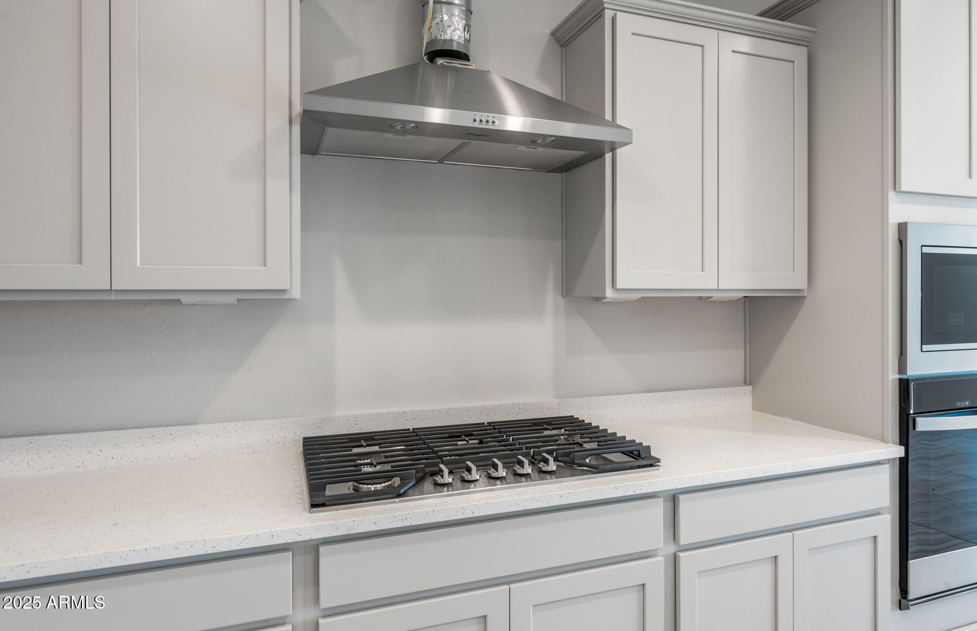 6795 West Ripken Way Florence, AZ 85132 - Photo 18 of 35 a kitchen with white cabinets and a stove