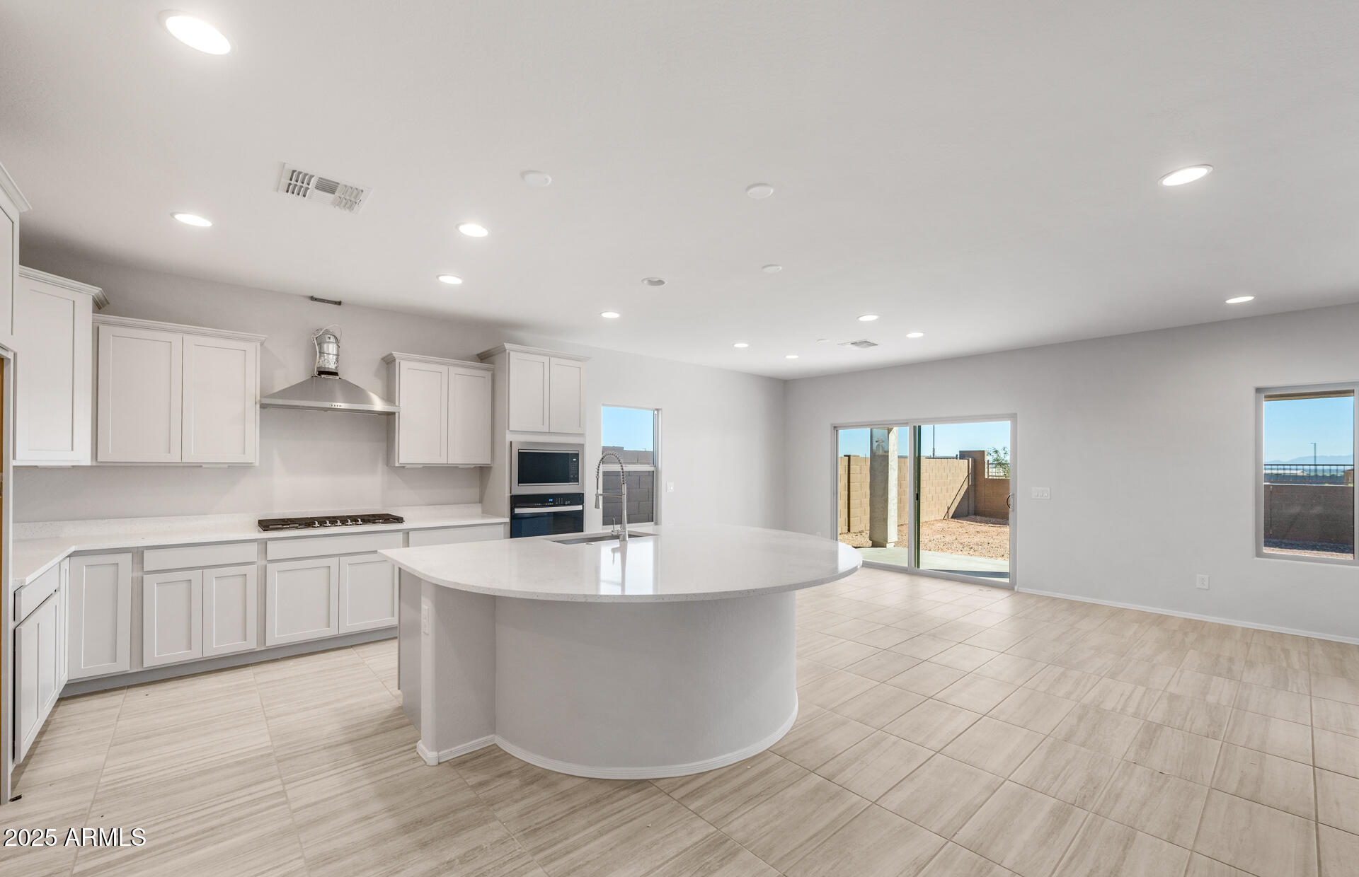 6795 West Ripken Way Florence, AZ 85132 - Photo 20 of 35 a large kitchen with kitchen island a stove a sink a refrigerator and cabinets