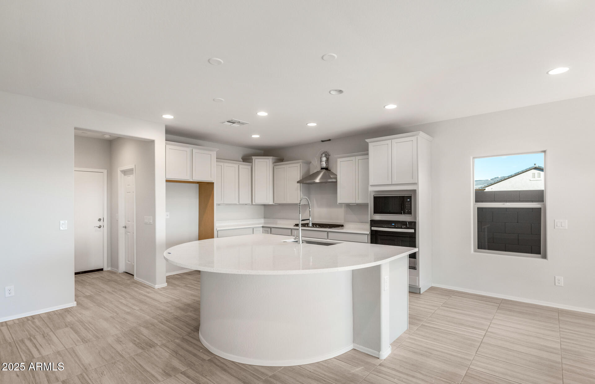 6795 West Ripken Way Florence, AZ 85132 - Photo 22 of 35 a large kitchen with stainless steel appliances a large counter top a refrigerator and a stove top oven