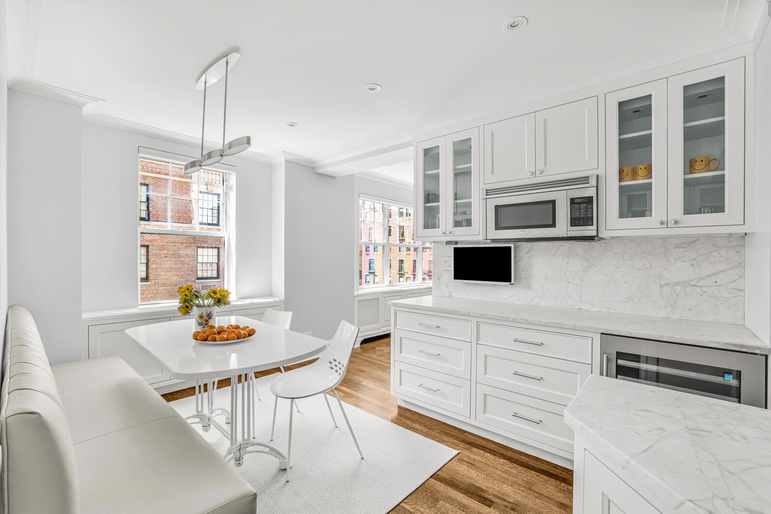 785 Park Avenue, Unit 13DE Manhattan, NY 10021 - Photo 5 of 15 a kitchen with stainless steel appliances a dining table chairs and granite counter tops