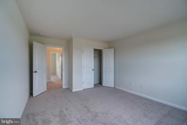 a view of an empty room and closet area