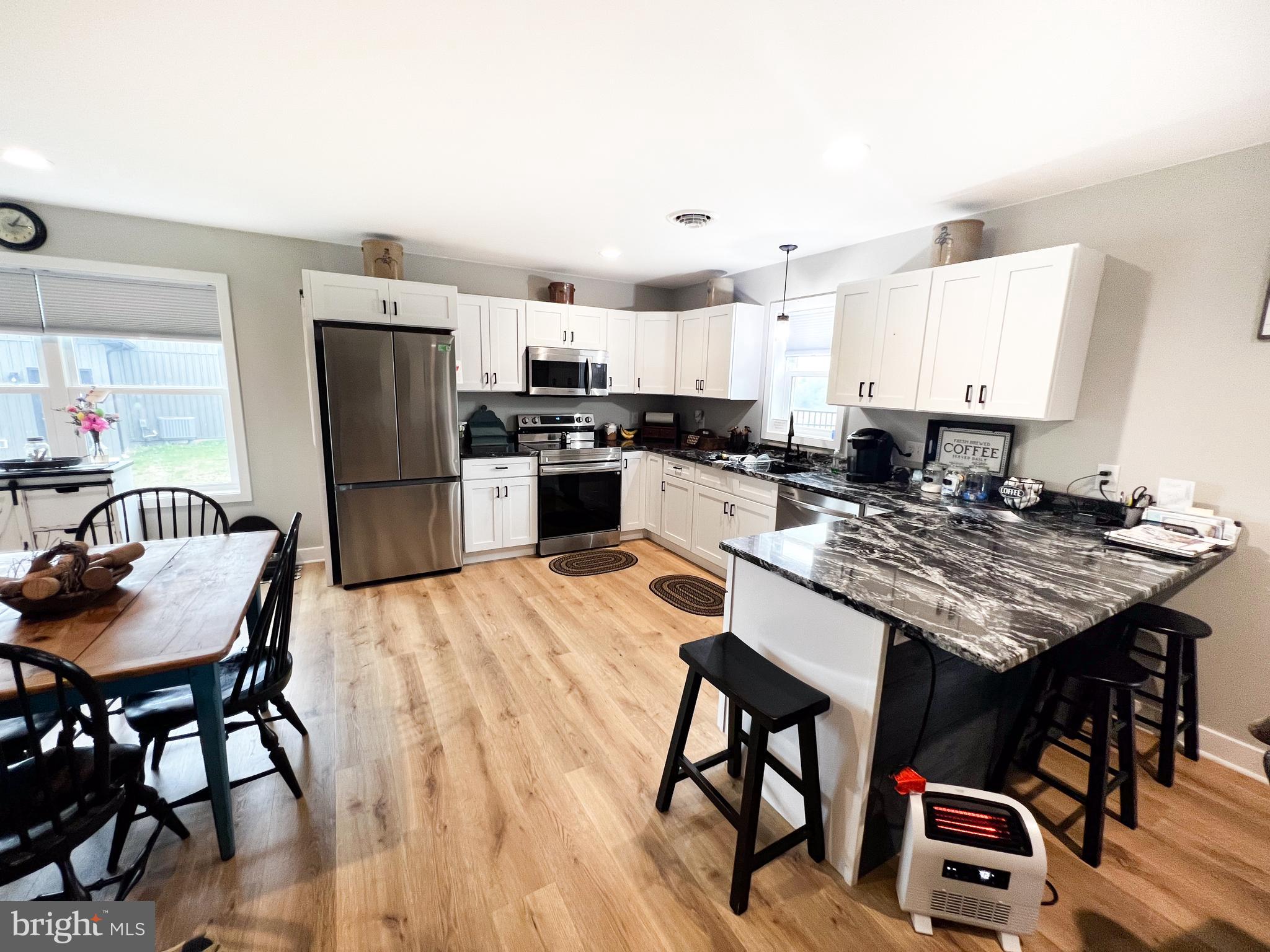 90 Tilbury Lane Reedsville, PA 17084 - Photo 16 of 28 a kitchen with stainless steel appliances granite countertop a stove a refrigerator a kitchen island and chairs with wooden floor