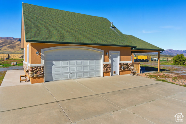 4768 East Hickman Canyon Road Stockton, UT 84071 - Photo 67 of 85 View of two car detached garage with a mountain view, stone siding and stucco siding.