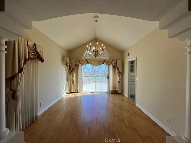 a view of a hallway with windows and chandelier