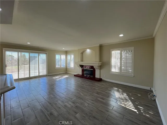 a view of empty room with wooden floor and fireplace