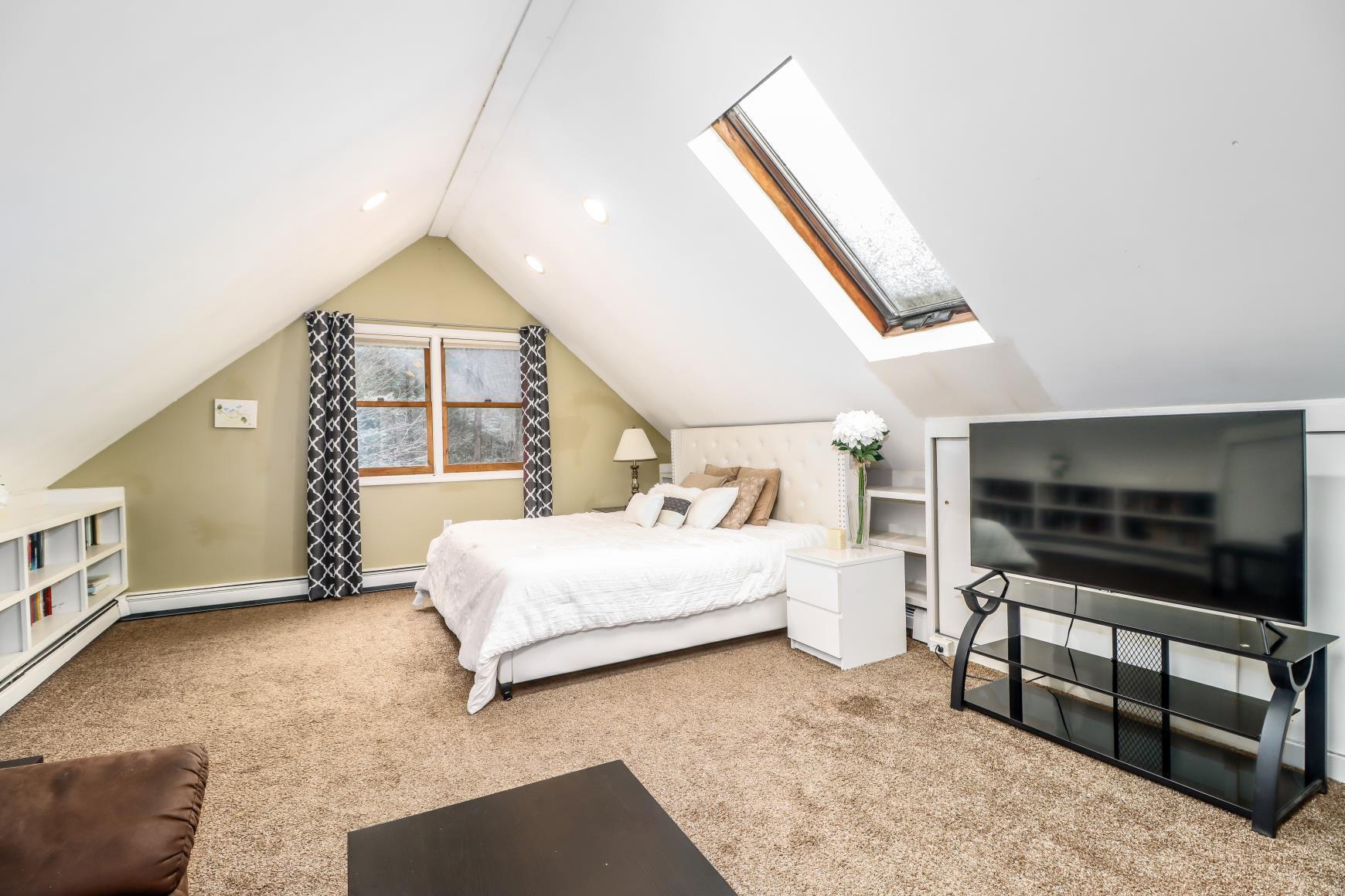 56 East Starrs Plain Road Danbury, CT 06810 - Photo 16 of 37 a spacious bedroom with a bed and a flat tv screen on wall