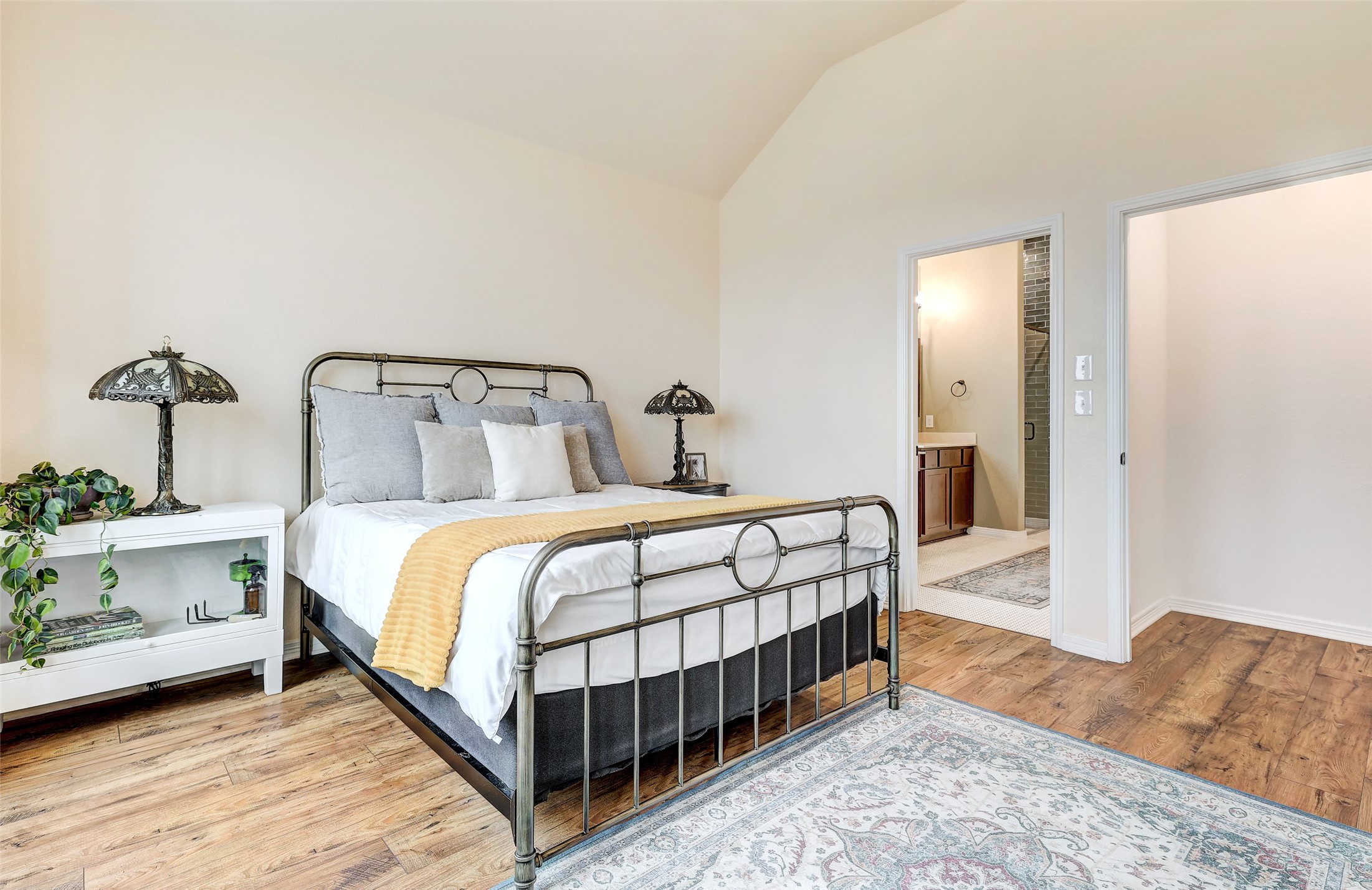 1117 Spring Gulch Lane Georgetown, TX 78628 - Photo 21 of 39 A well-lit bedroom features vaulted ceilings and rich wood flooring leading to a private bath.