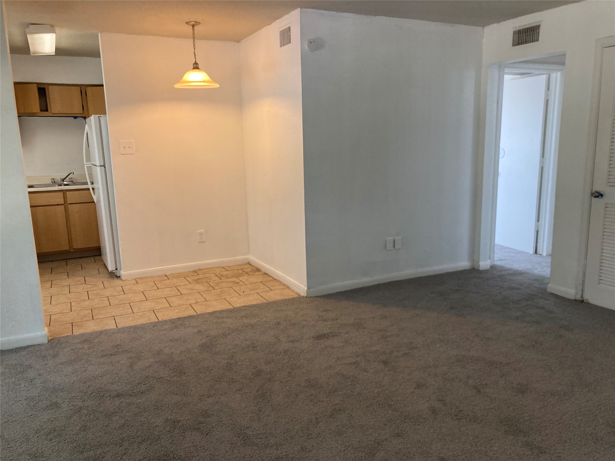 7201 Hallshire Drive, Unit 235 Houston, TX 77016 - Photo 5 of 10 a view of a refrigerator in kitchen and an empty room