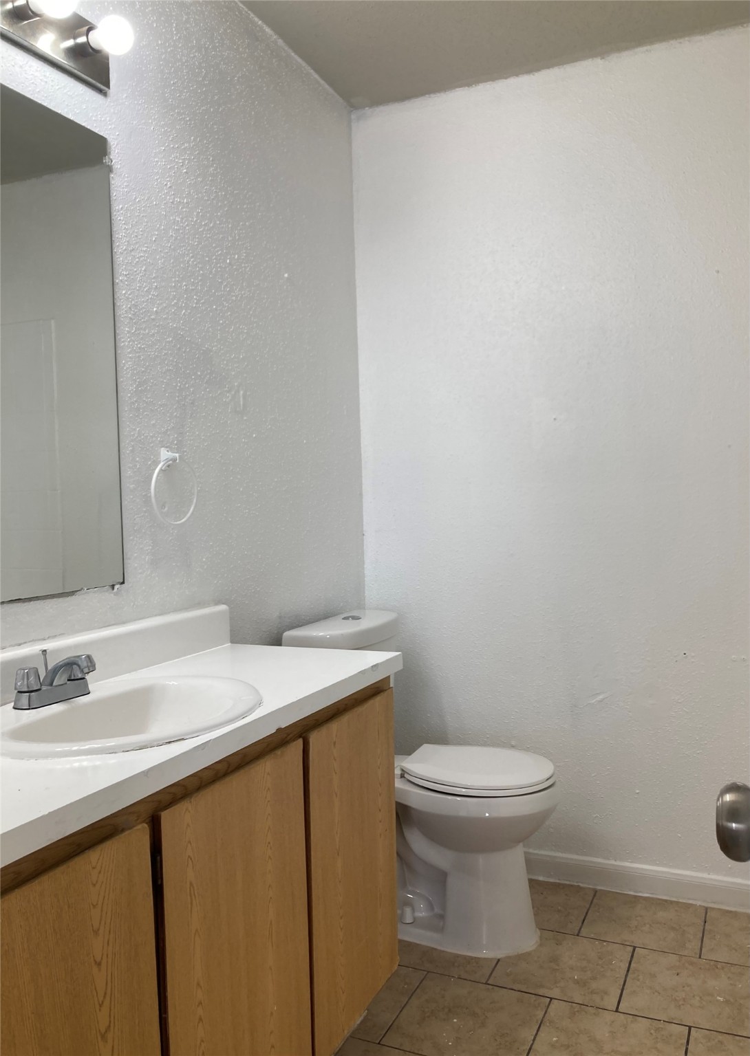 7201 Hallshire Drive, Unit 235 Houston, TX 77016 - Photo 6 of 10 a bathroom with a sink a toilet and a mirror