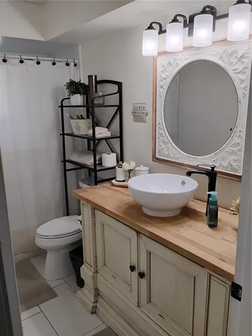 a bathroom with a granite countertop toilet sink and mirror