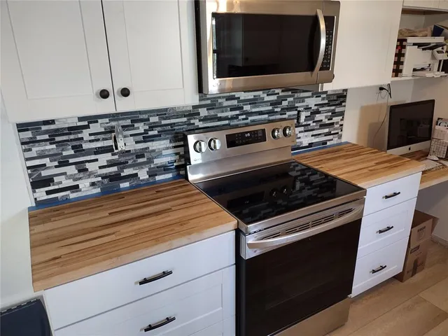a kitchen with stove top oven and cabinets