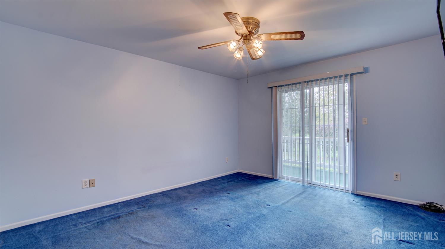 40 B Rutland Lane Monroe Township, NJ 08831 - Photo 13 of 31 an empty room with a chandelier fan and windows