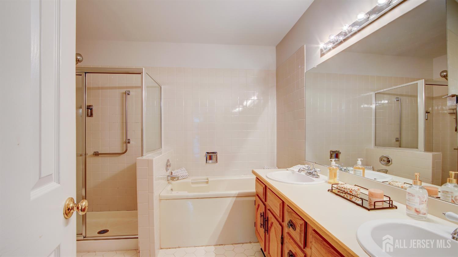 40 B Rutland Lane Monroe Township, NJ 08831 - Photo 16 of 31 a bathroom with a tub sink double vanity and mirror
