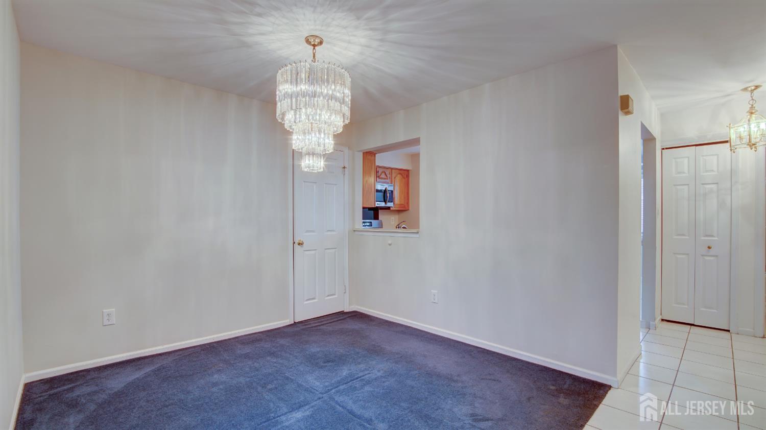 40 B Rutland Lane Monroe Township, NJ 08831 - Photo 8 of 31 an empty room with a chandelier fan and wooden floor
