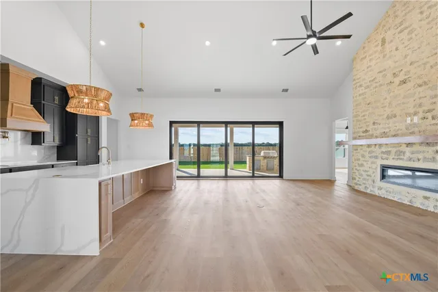 a view of an empty room with window and wooden floor