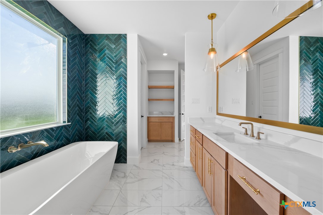 6830 Lacey Oak Road Salado, TX 76571 - Photo 22 of 34 a bathroom with a tub sink and mirror