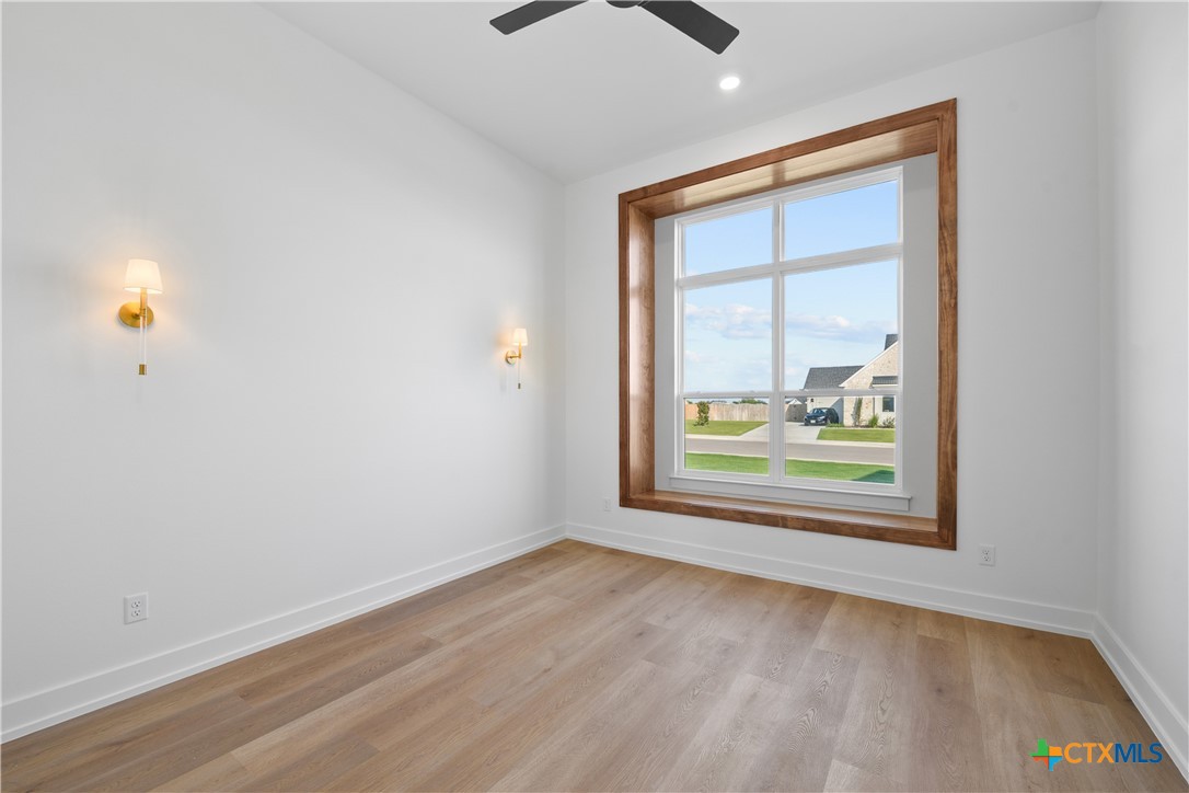 6830 Lacey Oak Road Salado, TX 76571 - Photo 31 of 34 an empty room with wooden floor and windows