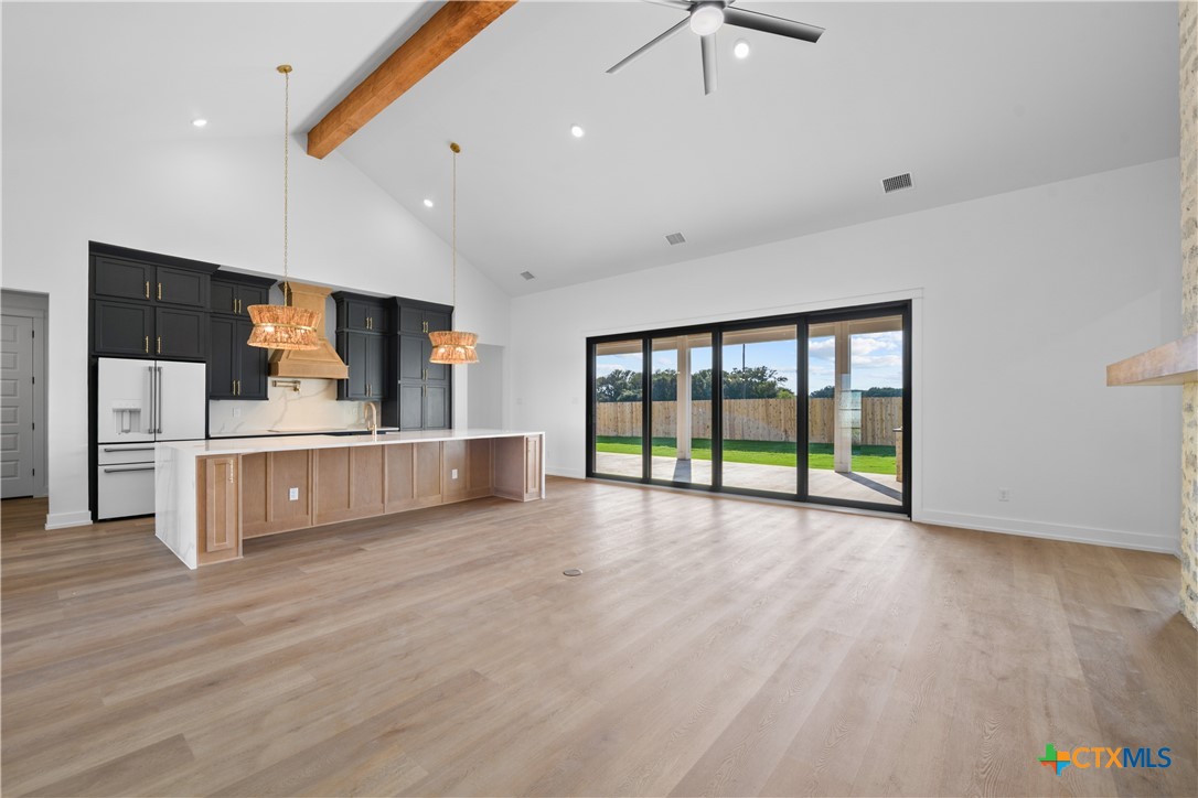 6830 Lacey Oak Road Salado, TX 76571 - Photo 5 of 34 a view of a kitchen with stainless steel appliances wooden floor and a large window