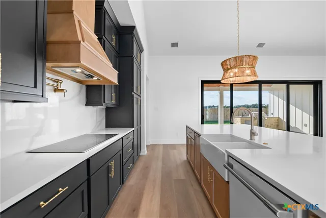 a kitchen with stainless steel appliances granite countertop a sink and a stove
