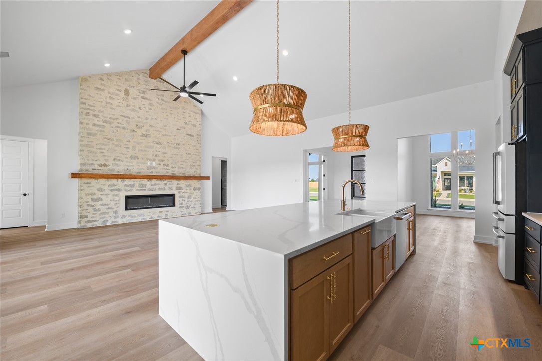 6830 Lacey Oak Road Salado, TX 76571 - Photo 9 of 34 a large kitchen with stainless steel appliances granite countertop a stove and wooden floors