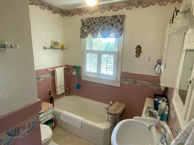a bathroom with a sink mirror bathtub and toilet